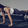 Woman doing a medicine ball plank during a high-intensity interval training workout